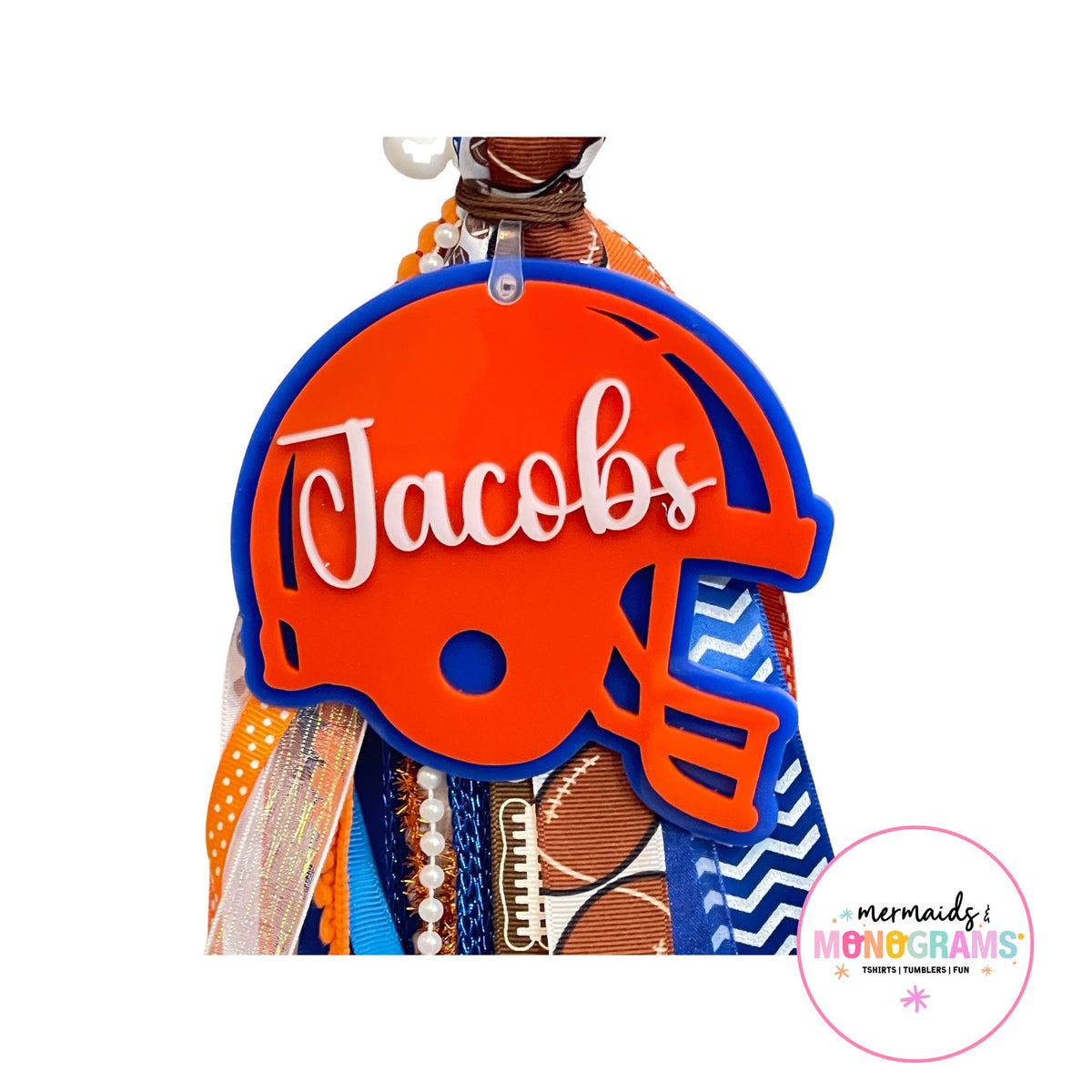 Close-up of personalized acrylic football helmet name tag with “Jacobs” in white script