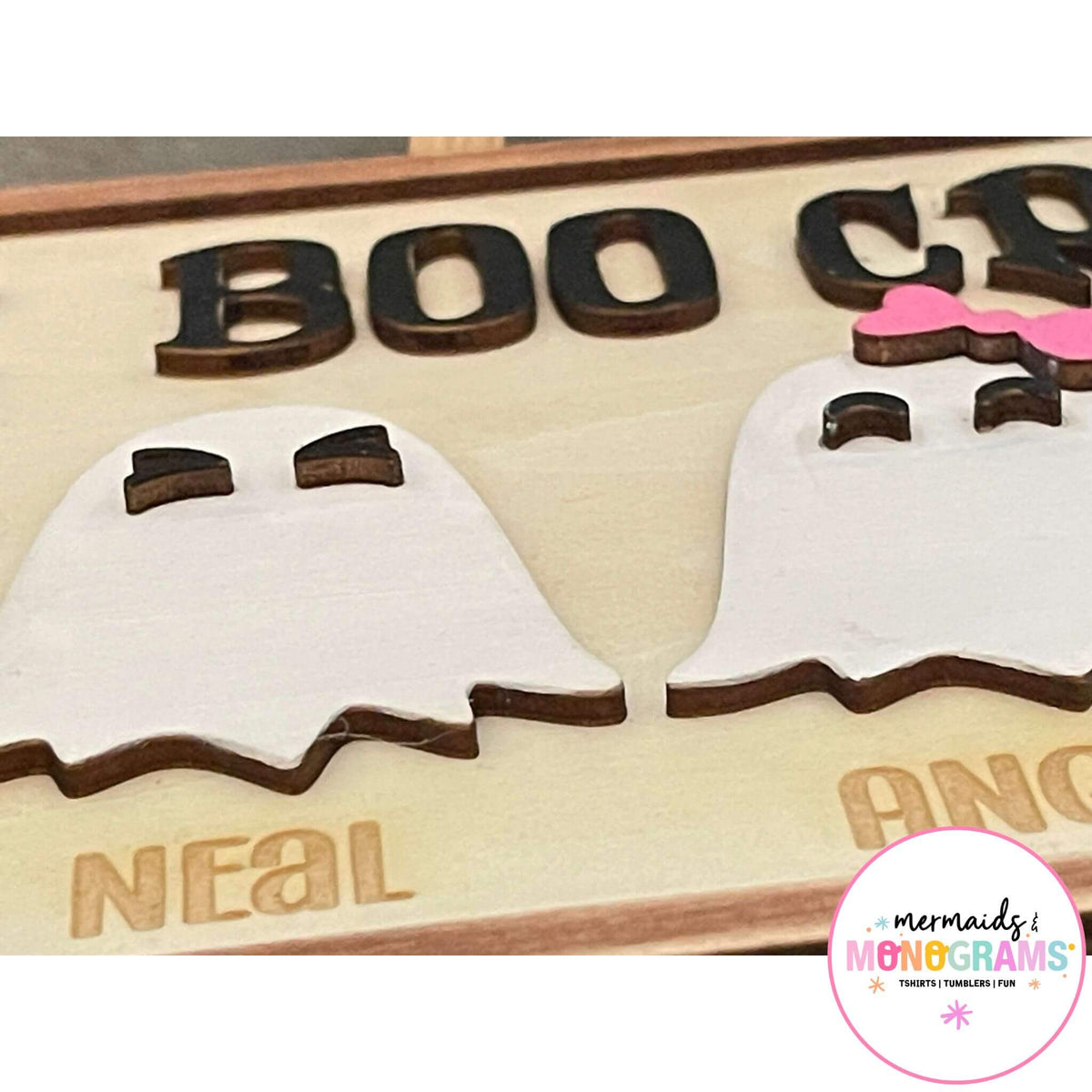 Zoomed-in Halloween Boo Crew sign showing laser engraved ghost characters and individual names like Angela and Neal