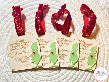Four laser-engraved wooden Grinch Christmas ornaments with red glitter bows, featuring the quote "Maybe Christmas doesn’t come from a store..." and a green acrylic Grinch silhouette with a red heart.