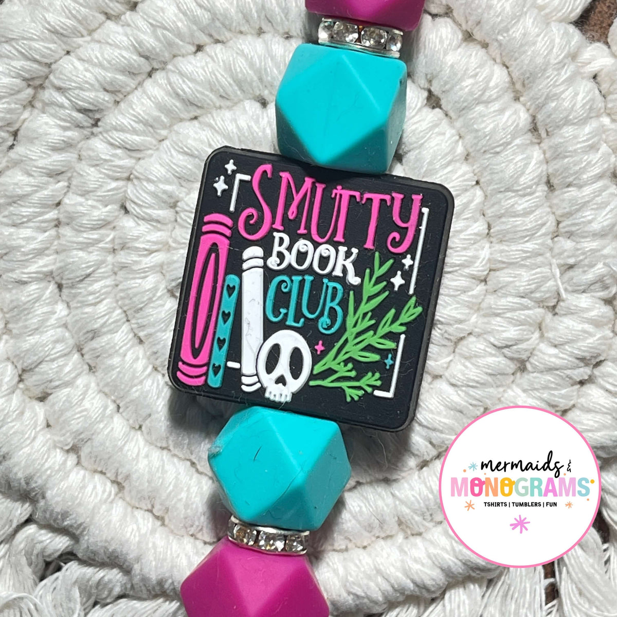 Badge holder with 'Smutty Book Club' design on a textured white background